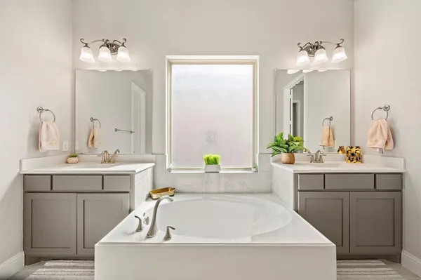 a bathroom with a tub sink and mirror