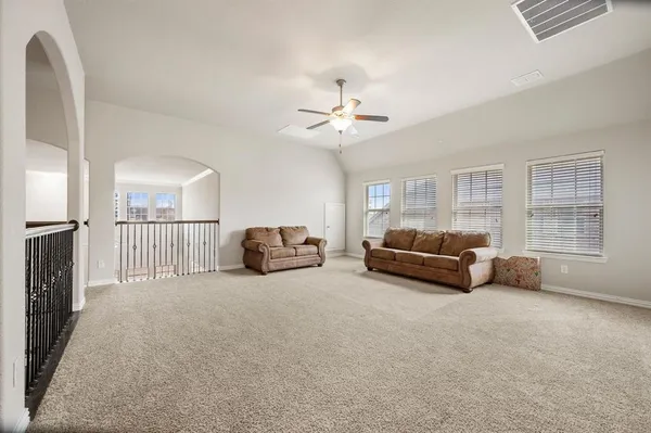 a living room with furniture a ceiling fan a couch and a window