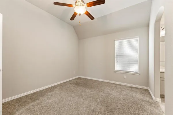 an empty room with a window and a ceiling fan
