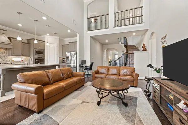 a living room with furniture a flat screen tv and kitchen view