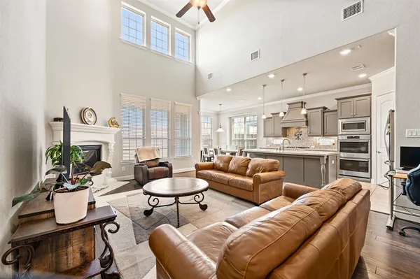 a living room with furniture kitchen view and a large window