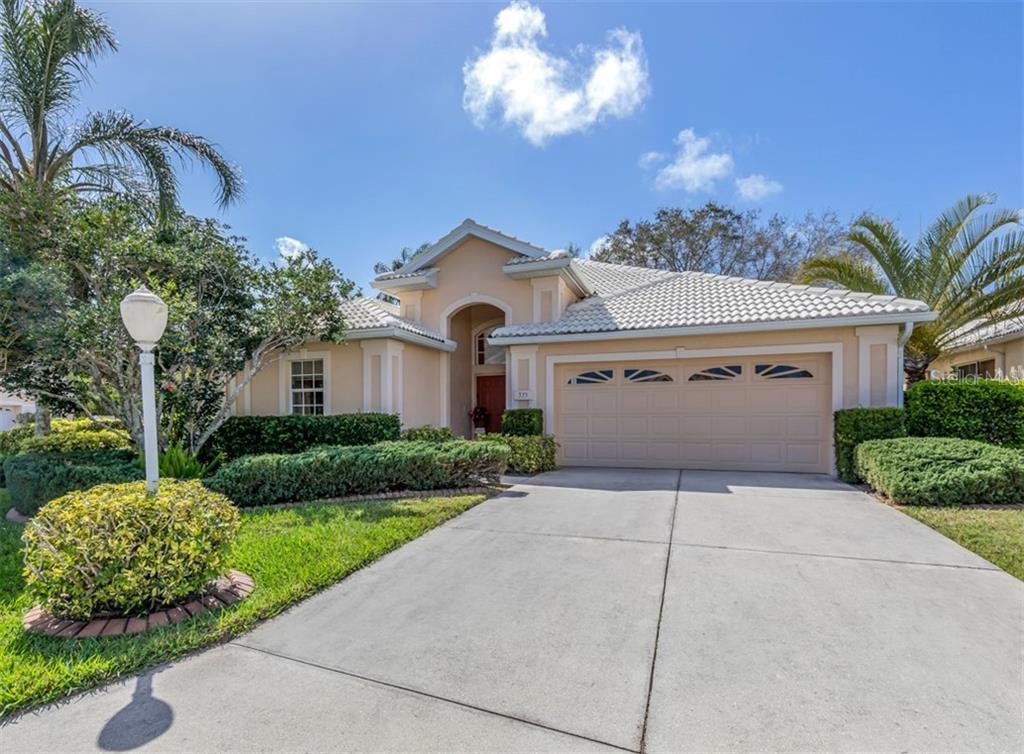 335 St George Court, Unit 1 Venice, FL 34293 - Photo 1 of 1 a front view of a house with a yard and garage