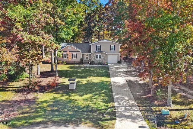 a front view of a house with a yard porch and wooden fence