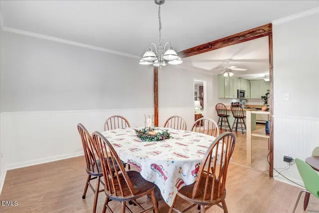 a view of a dining room and livingroom with furniture wooden floor a chandelier