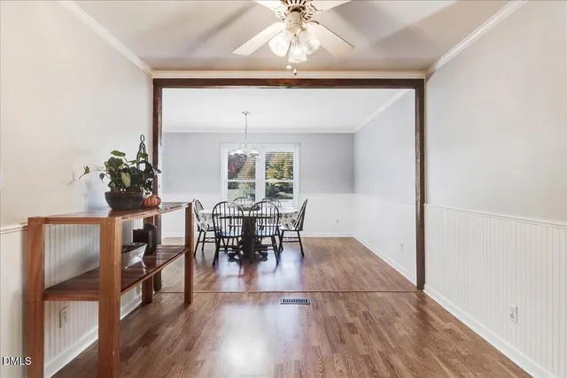 a kitchen with stainless steel appliances granite countertop a refrigerator a stove a sink dishwasher and white cabinets with wooden floor