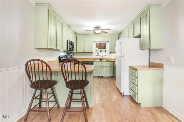 a kitchen with stainless steel appliances granite countertop a sink a stove a refrigerator with a dining table and chairs