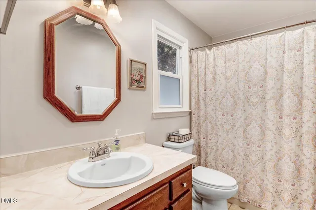 an empty room with windows and fireplace