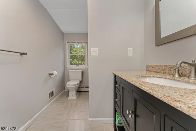 a bathroom with a granite countertop sink and toilet