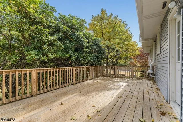 a balcony with wooden floor and yard in the back