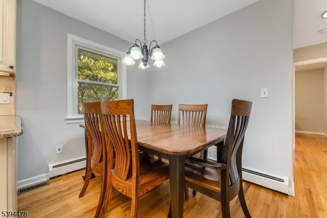 a view of a dining room with furniture a chandelier and wooden floor