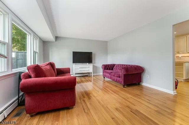 a living room with furniture a flat screen tv and a floor to ceiling window