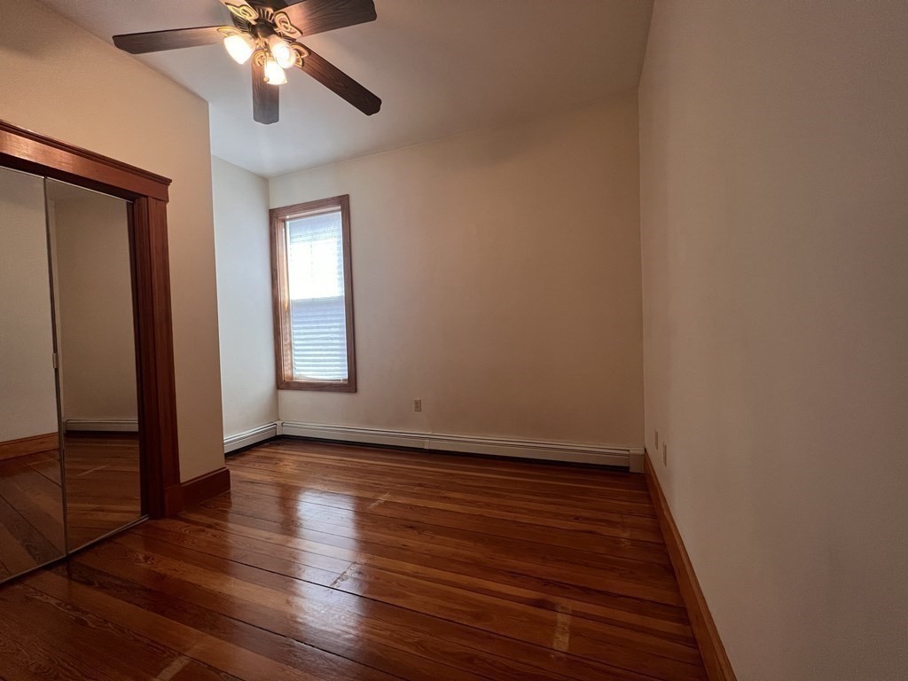 18 Houghton Street, Unit 1 Somerville, MA 02143 - Photo 11 of 13 a view of an empty room with wooden floor and a window