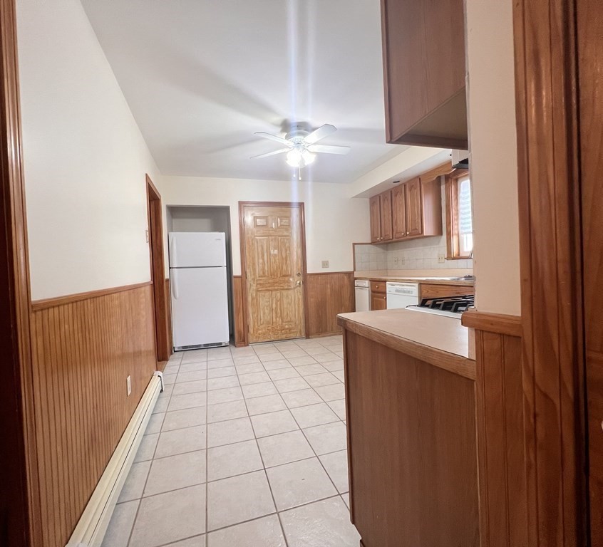 18 Houghton Street, Unit 1 Somerville, MA 02143 - Photo 4 of 13 a kitchen with kitchen island granite countertop a refrigerator a sink and a stove