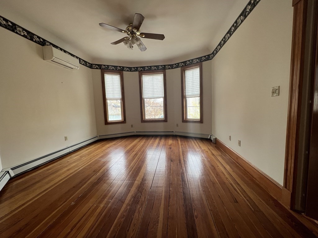 18 Houghton Street, Unit 1 Somerville, MA 02143 - Photo 5 of 13 a view of empty room with wooden floor and fan