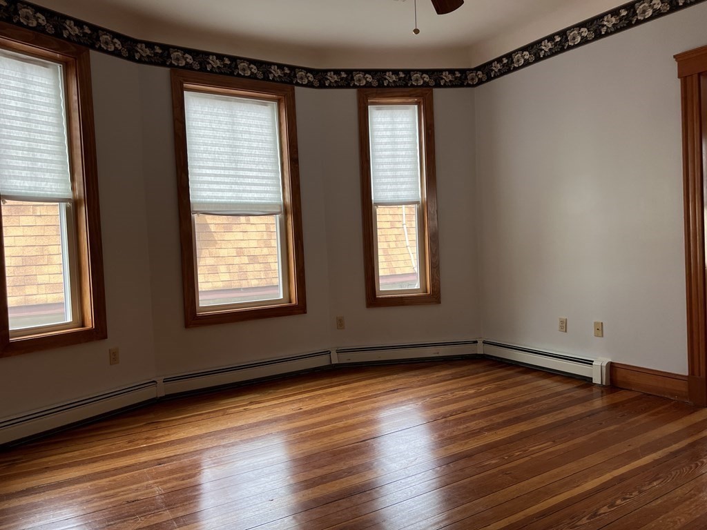 18 Houghton Street, Unit 1 Somerville, MA 02143 - Photo 7 of 13 a view of an empty room with wooden floor and a window