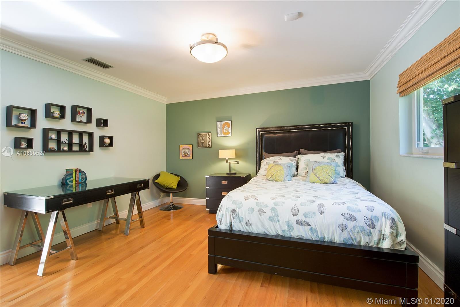 12440 Moss Ranch Road Pinecrest, FL 33156 - Photo 16 of 33 a bedroom with a bed a table and chair