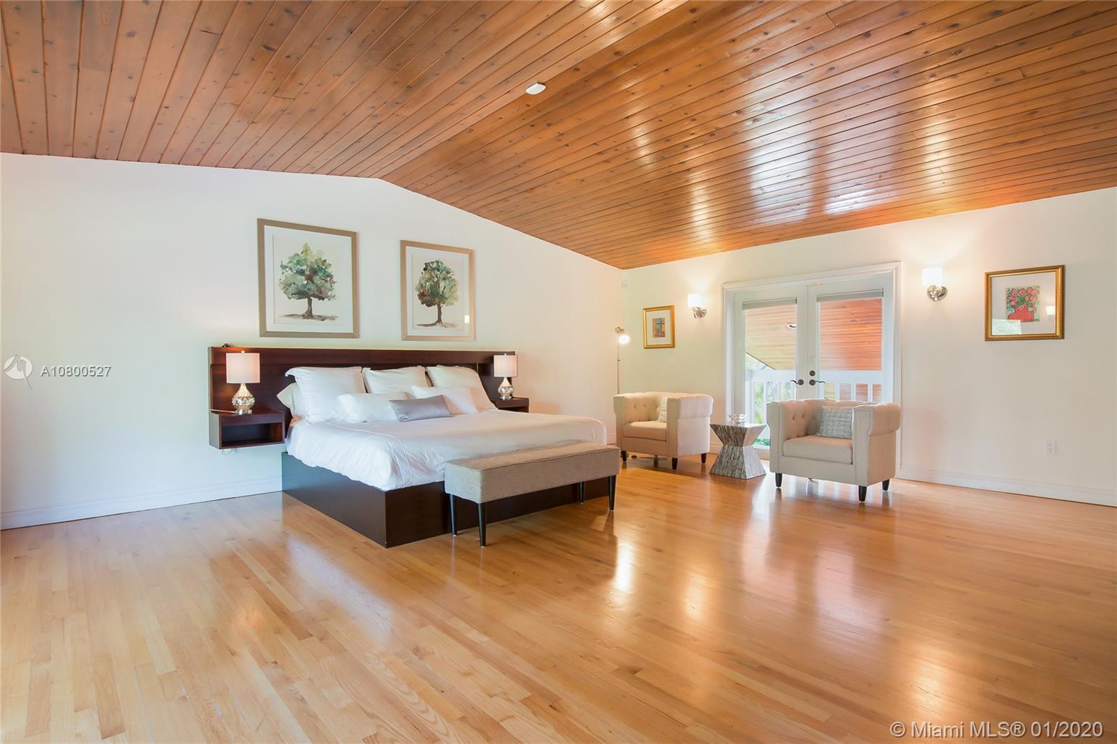 12440 Moss Ranch Road Pinecrest, FL 33156 - Photo 19 of 33 a spacious bedroom with a bed and wooden floor