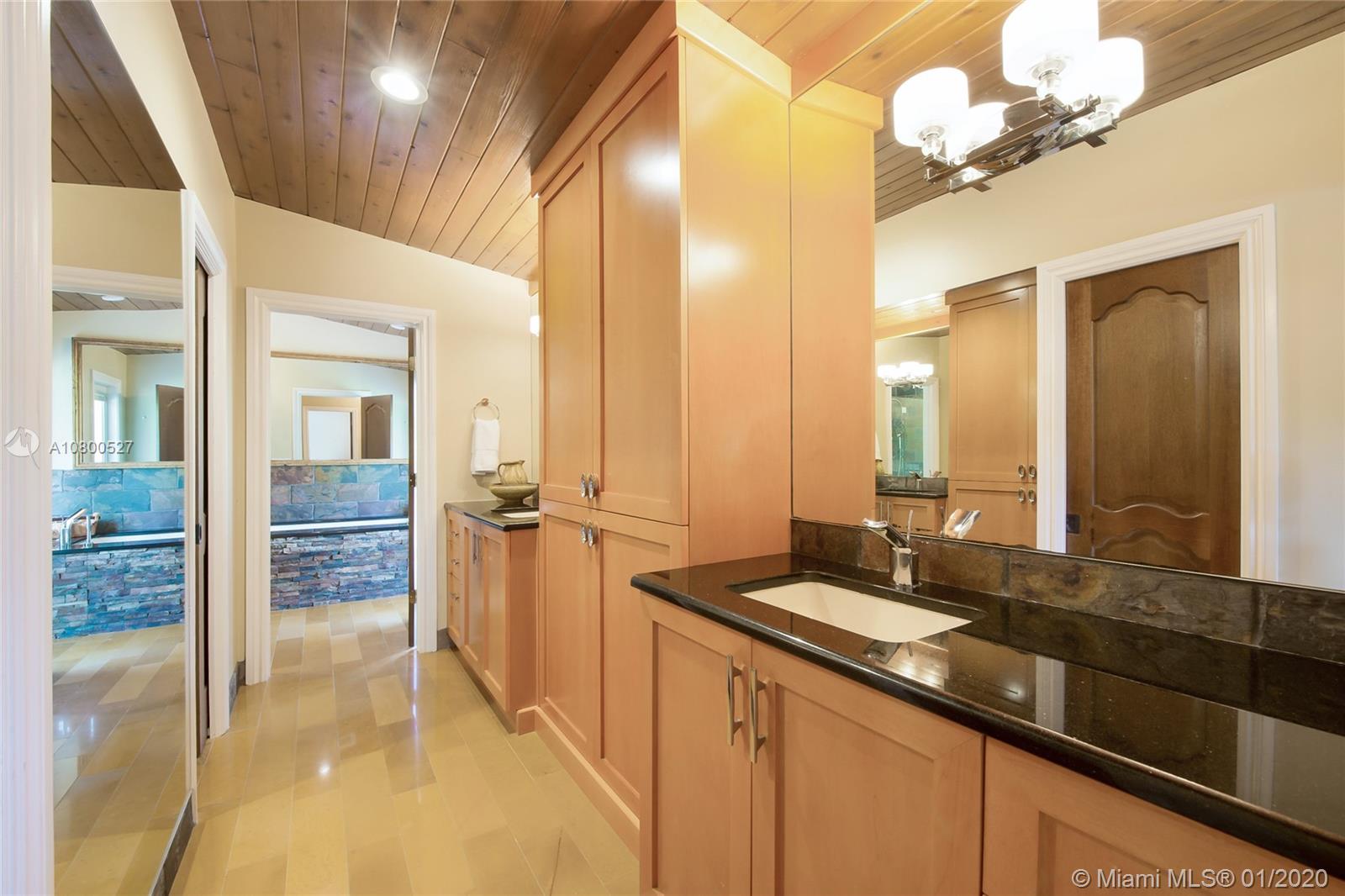 12440 Moss Ranch Road Pinecrest, FL 33156 - Photo 20 of 33 a bathroom with a double vanity sink a mirror and a shower
