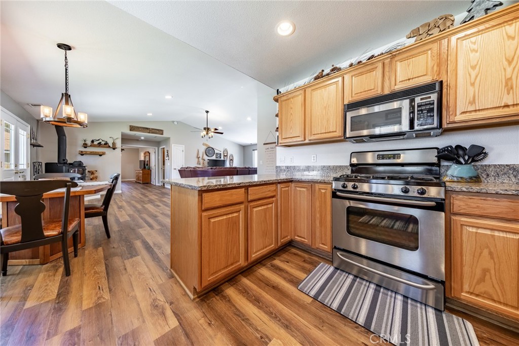 643 Purdy Road Chester, CA 96020 - Photo 8 of 29 a kitchen with stainless steel appliances granite countertop a stove top oven a sink dishwasher and white cabinets with wooden floor