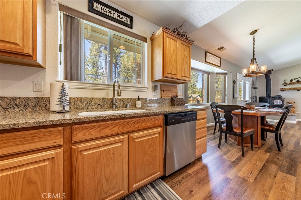 643 Purdy Road Chester, CA 96020 - Photo 10 of 29 a kitchen with stainless steel appliances granite countertop a stove a sink dishwasher a dining table and chairs with wooden floor