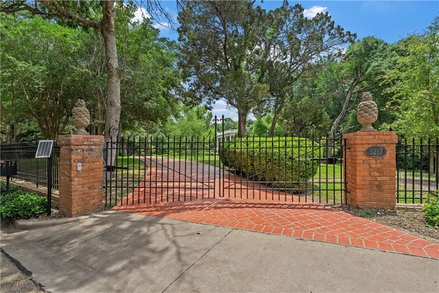a view of a backyard with a fence and trees