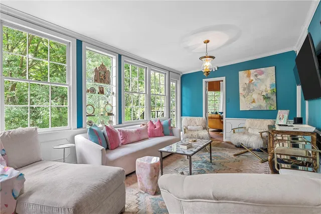 a living room with furniture and a floor to ceiling window