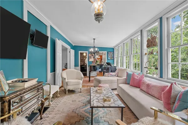 a living room with furniture a flat screen tv and a floor to ceiling window