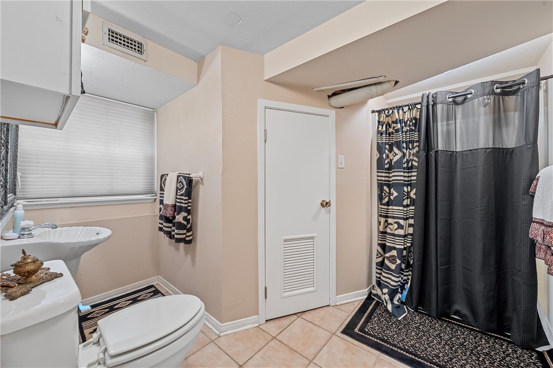 3217 Robin Road Waco, TX 76708 - Photo 54 of 61 a bathroom with a toilet a sink and shower