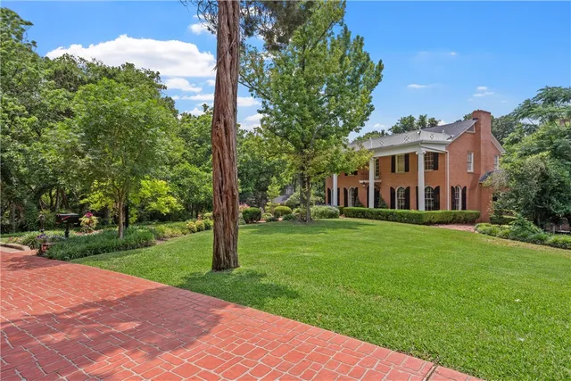 a front view of a house with a yard and fountain