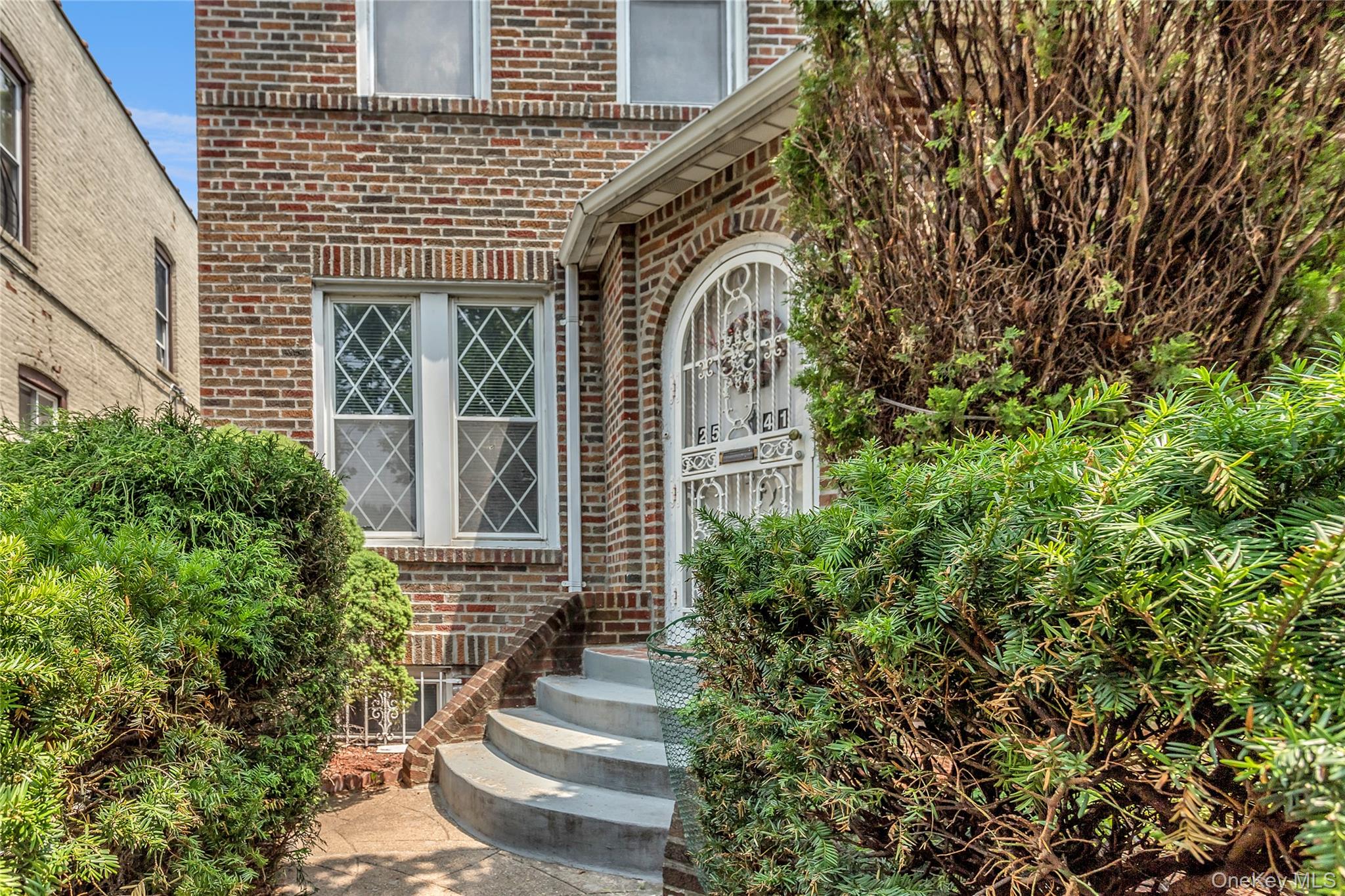 25-41 83rd Street Queens, NY 11370 - Photo 2 of 15 a front view of a house with a tree