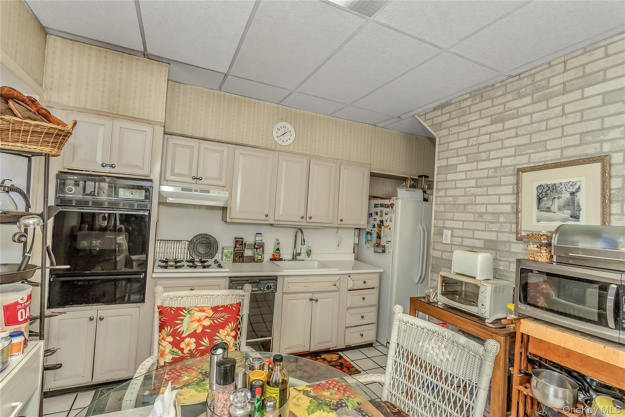 25-41 83rd Street Queens, NY 11370 - Photo 7 of 15 a kitchen with stainless steel appliances a sink a stove a refrigerator cabinets and a dining table