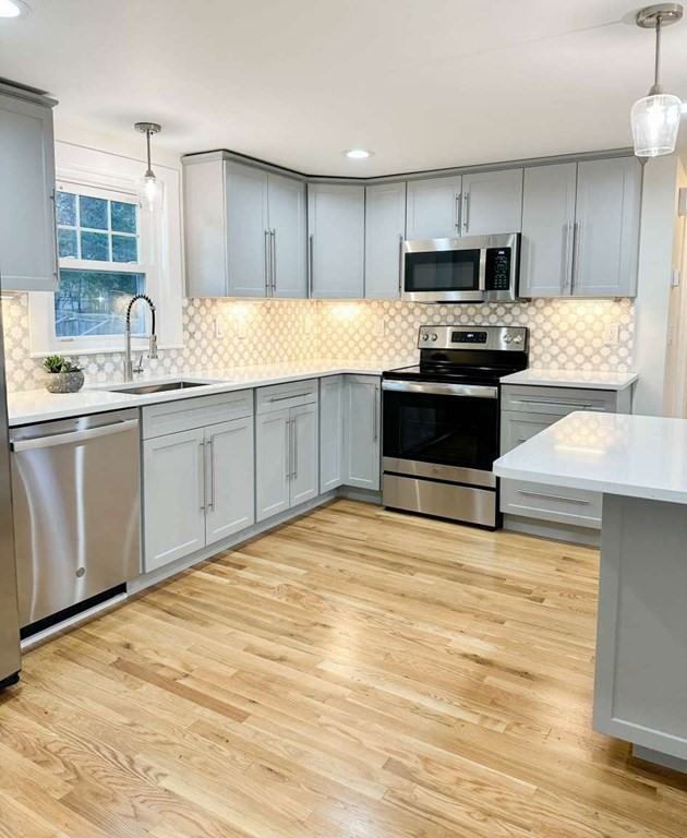 93 Moosehill Road East Walpole, MA 02032 - Photo 3 of 18 a kitchen with granite countertop a stove a sink and a microwave