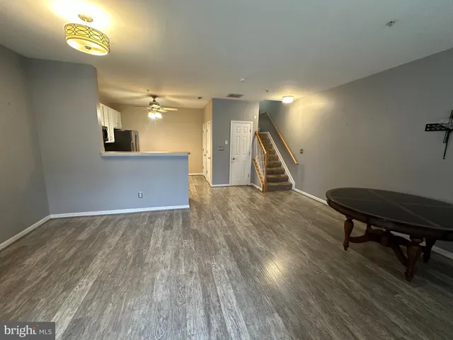 a view of a livingroom with wooden floor and a staircase