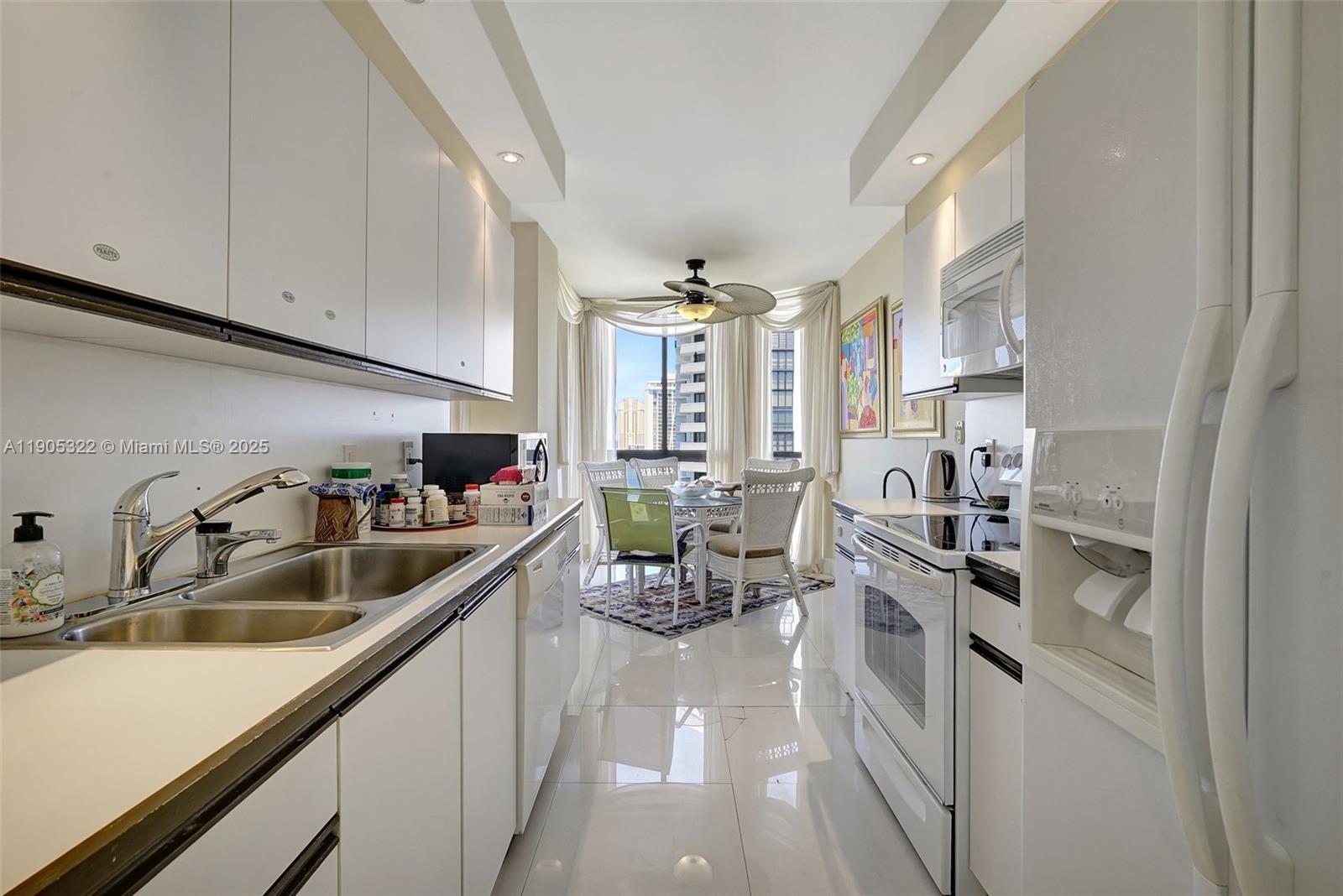 1000 East Island Boulevard, Unit 2004 Aventura, FL 33160 - Photo 15 of 45 a kitchen with white cabinets and sink