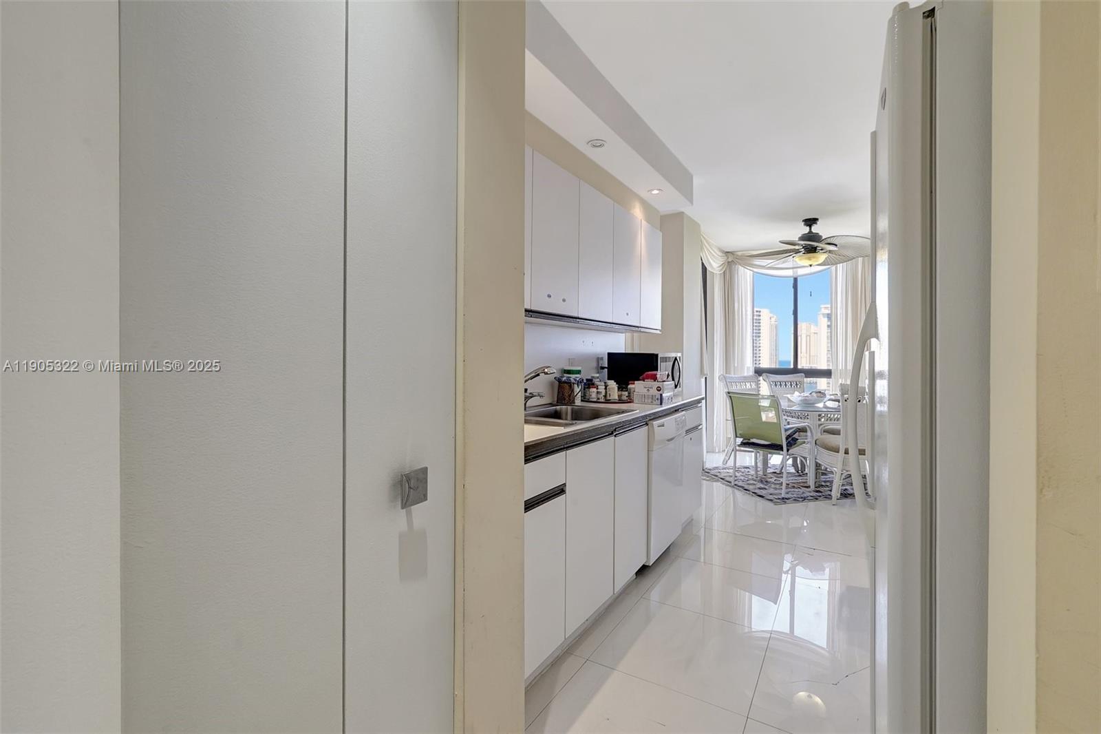 1000 East Island Boulevard, Unit 2004 Aventura, FL 33160 - Photo 18 of 45 a kitchen with white cabinets and appliances