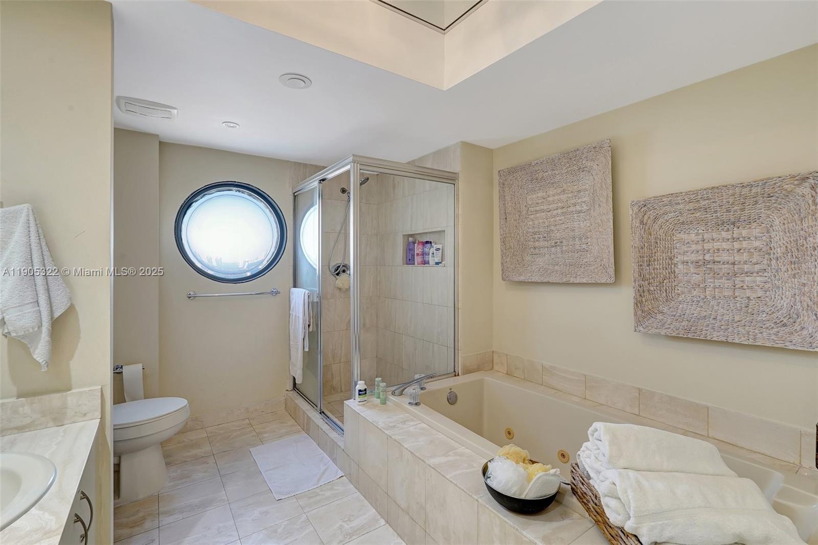 1000 East Island Boulevard, Unit 2004 Aventura, FL 33160 - Photo 25 of 45 a bathroom with a tub a toilet and a mirror