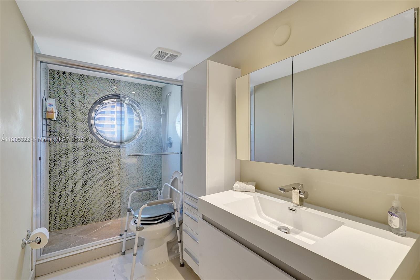 1000 East Island Boulevard, Unit 2004 Aventura, FL 33160 - Photo 31 of 45 a bathroom with a toilet a sink and a mirror