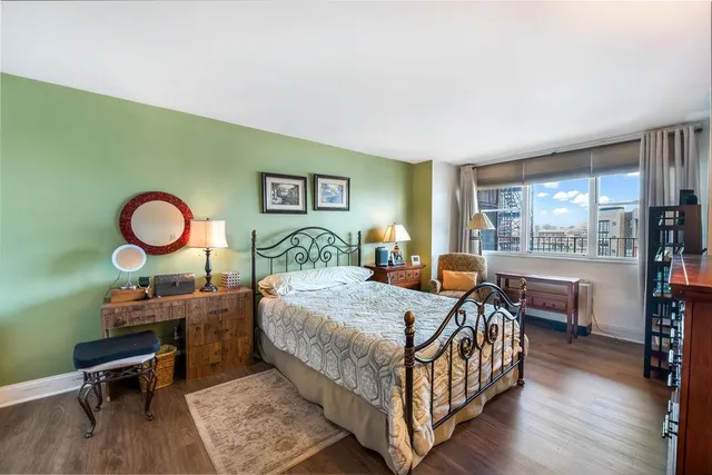 a bedroom with a bed window and a table in it