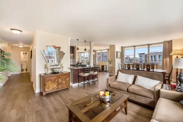 a living room with furniture wooden floor and a large window