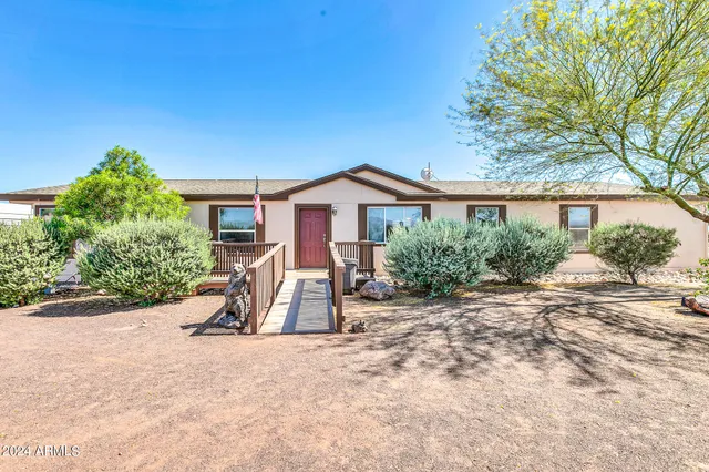 a view of a house with a yard and large tree