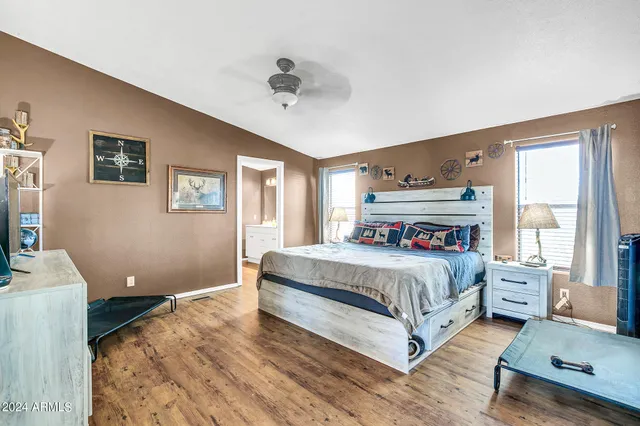 a bed sitting in a bedroom next to a window with a large window and a table