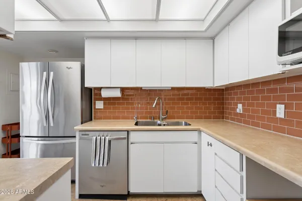 a kitchen with appliances a sink and cabinets