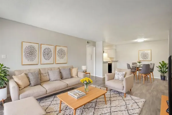 a living room with furniture a chandelier and a dining table
