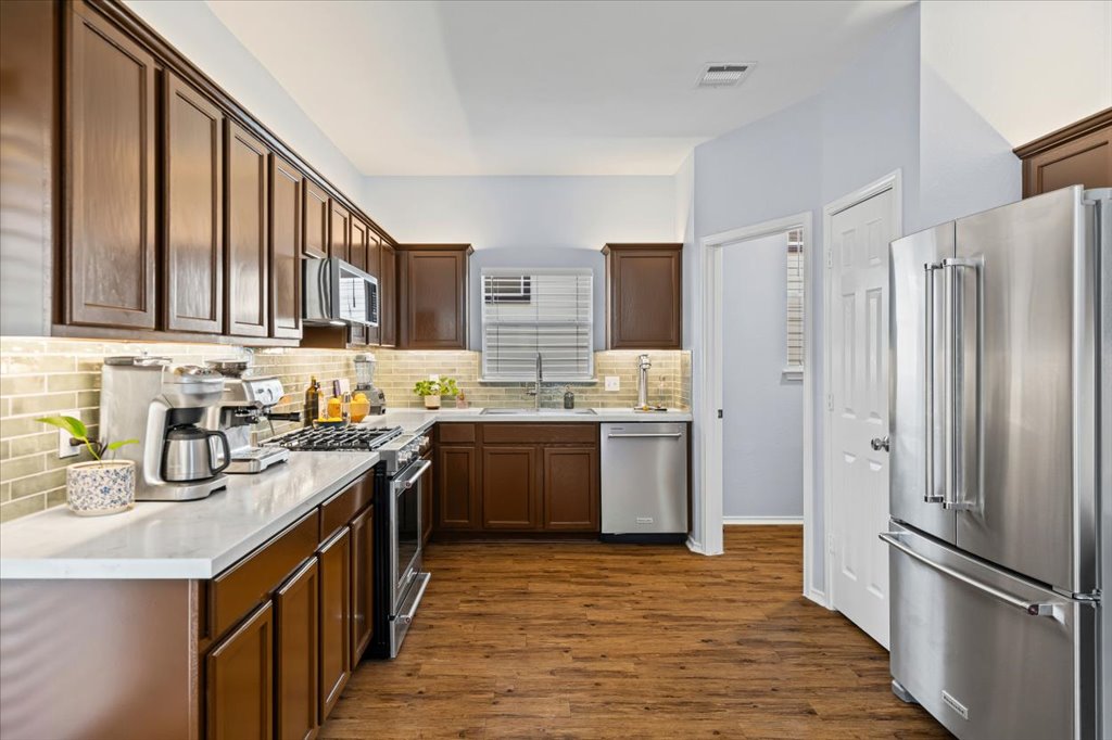a kitchen with a sink refrigerator and cabinets