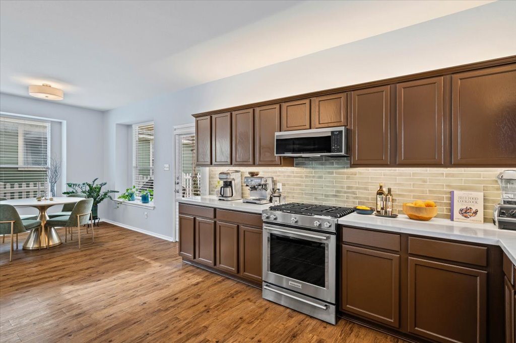 501 Sampson Kyle, TX 78640 - Photo 11 of 31 a kitchen with stainless steel appliances wooden cabinets and a stove top oven