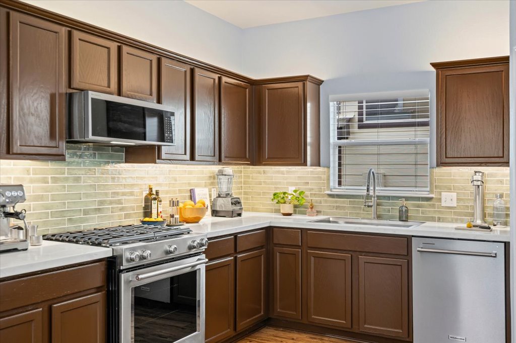 501 Sampson Kyle, TX 78640 - Photo 10 of 31 a kitchen with stainless steel appliances a stove sink microwave and cabinets