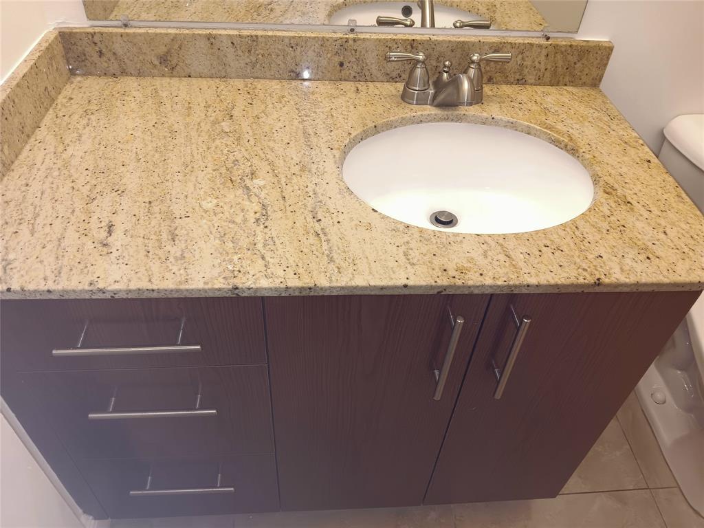 1265 Southwest 46th Avenue, Unit 2207 Pompano Beach, FL 33069 - Photo 15 of 33 a bathroom with a granite countertop sink and a mirror