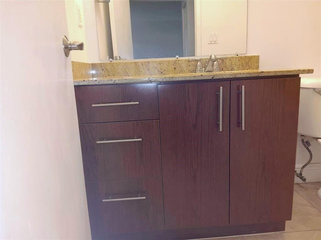 1265 Southwest 46th Avenue, Unit 2207 Pompano Beach, FL 33069 - Photo 16 of 33 a bathroom with a granite countertop sink and a mirror