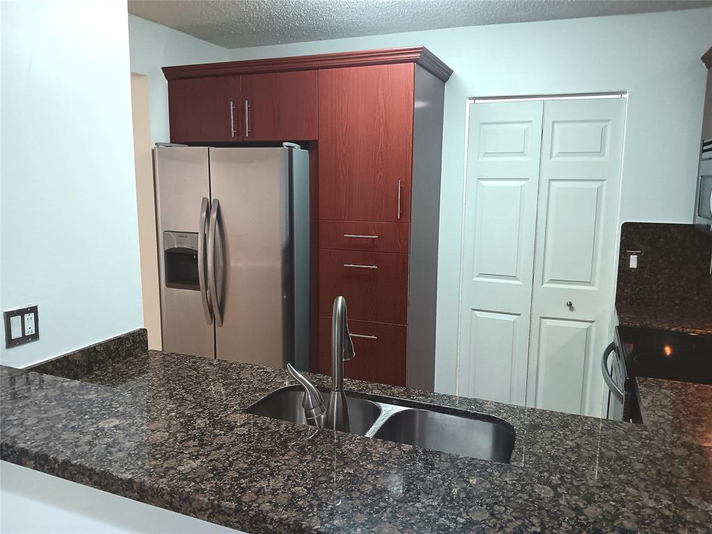 1265 Southwest 46th Avenue, Unit 2207 Pompano Beach, FL 33069 - Photo 3 of 33 a kitchen with stainless steel appliances granite countertop a refrigerator and a sink