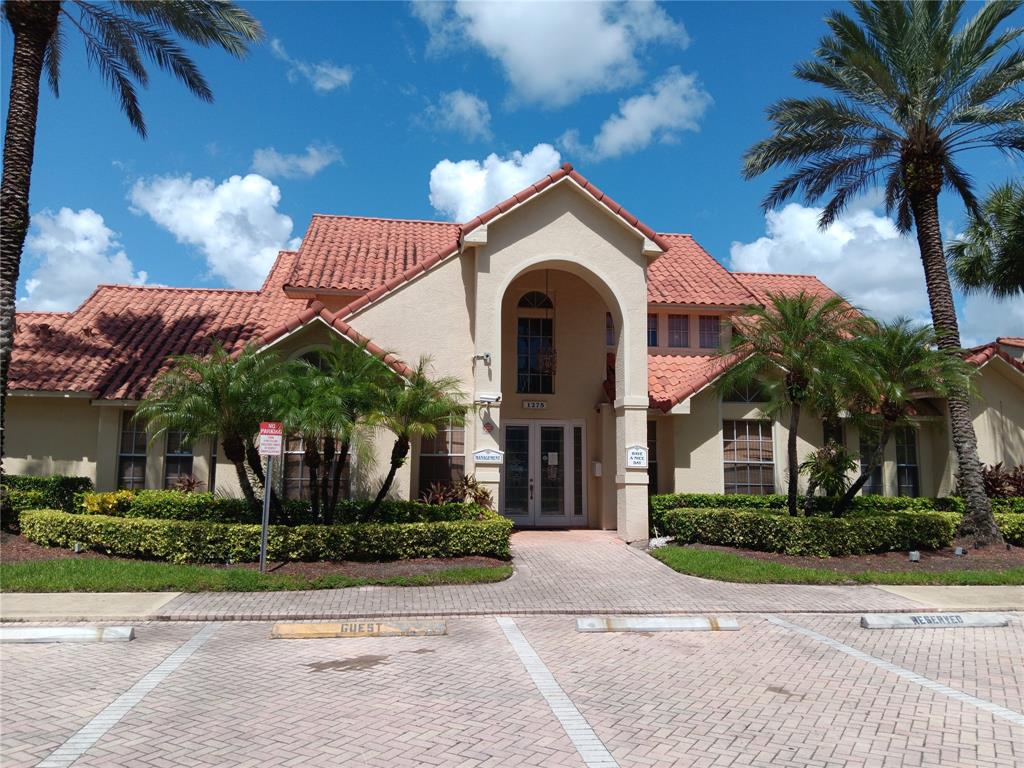 1265 Southwest 46th Avenue, Unit 2207 Pompano Beach, FL 33069 - Photo 32 of 33 a view of a white house with a yard and palm trees